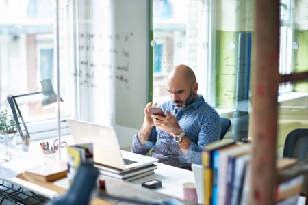 businessman using mobile phone at desk in modern office