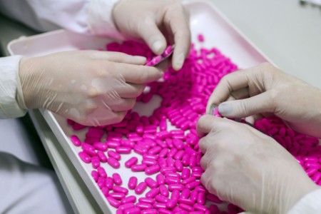 Quality Control Workers Examining Pills in Lab