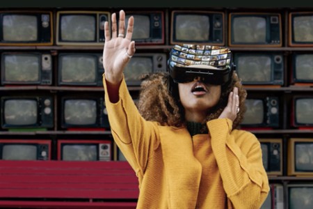 Woman watching videowall with VR goggles